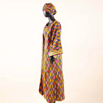 Mannequin wearing a colorful patterned dress and headscarf on a white background